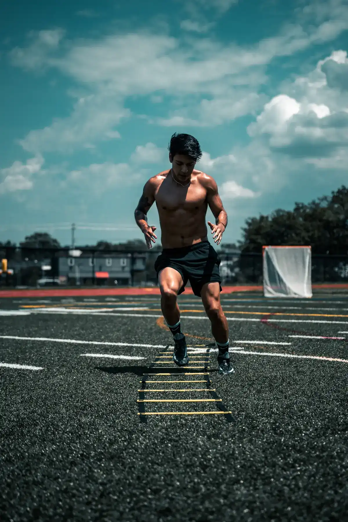 Soccer player training outdoors with the agility ladder